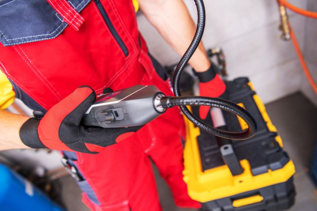 Worker holding a portable gas meter tool for gas installation