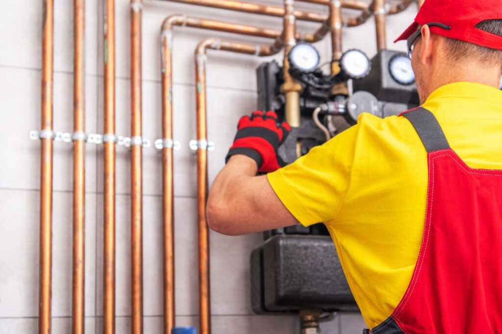 Worker fixing a gas meter and pipes