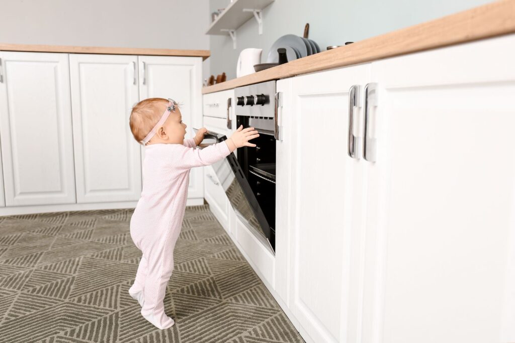 Baby holding the cooking range handle