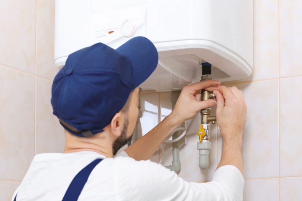 Man working on hot water system pipe